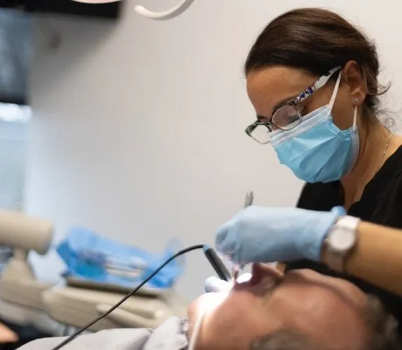 A Westchester Dental Group hygienist cleaning a patient's teeth.