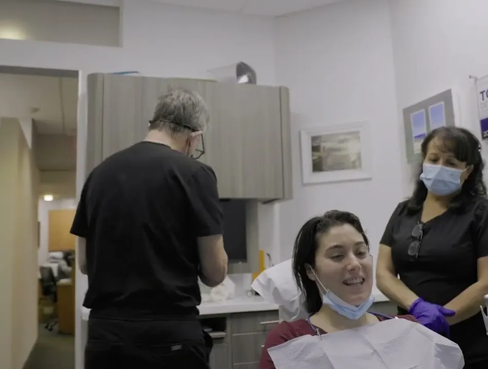 A dentist and an assistant with a patient in a Westchester Dental Group treatment room.